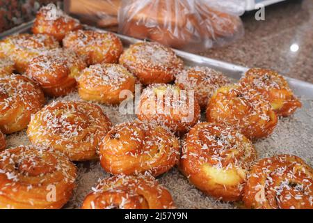 Süße Brötchen mit weißer Kokosnuss, ausgestellt in der lokalen jordanischen Bäckerei, Nahaufnahme Detail. Stockfoto