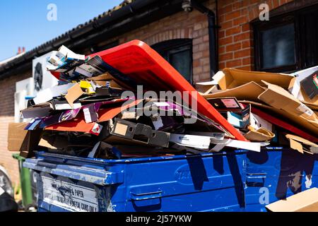 Woodbridge Suffolk UK April 20 2022: Überfließende gewerbliche Abfalleimer voller Kartonrecycling sitzen hinter einem Laden, der nicht gesammelt wurde Stockfoto