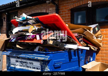 Woodbridge Suffolk UK April 20 2022: Überfließende gewerbliche Abfalleimer voller Kartonrecycling sitzen hinter einem Laden, der nicht gesammelt wurde Stockfoto