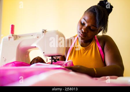 die afroamerikanische Schneiderin kreiert eine Kollektion von Outfits Stockfoto