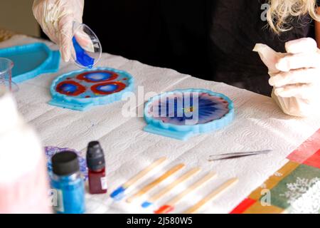 Frau Herstellung Epoxidharz Kunst und Kunsthandwerk. Stockfoto