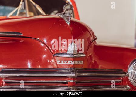 7/31/2021 - Sharjah, VAE: Klassisches rotes Plymouth-Auto aus 1950s Nahaufnahme von Motorhaube und Stoßstange mit Logo Stockfoto