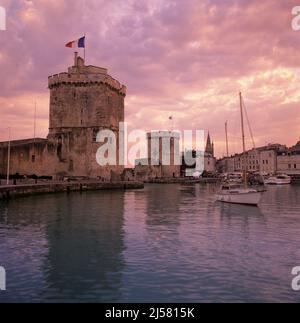 Der alte Hafen mit der Tour de la Chaine und den St. Nicolas Türmen bei Sonnenuntergang, La Rochelle, Nouvelle Aquitaine, Atlantikküste, Frankreich, Europa Stockfoto