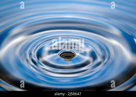 Tropfenfotografie, Wassertropfen fallen auf Wasseroberflaeche, Wassersaeule, Farbspiel, Studioaufnahme Stockfoto