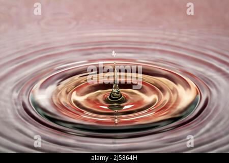 Tropfenfotografie, Wassertropfen fallen auf Wasseroberflaeche, Wassersaeule, Farbspiel, Studioaufnahme Stockfoto