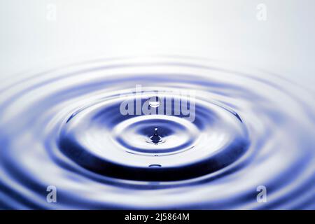 Tropfenfotografie, Wassertropfen fallen auf Wasseroberflaeche, Wassersaeule, Farbspiel, Studioaufnahme Stockfoto