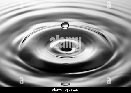 Tropfenfotografie, Wassertropfen fallen auf Wasseroberflaeche, Wassersaeule, Farbspiel, Studioaufnahme Stockfoto