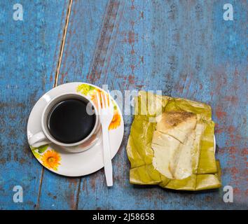 Gefülltes Tamale auf Holztisch serviert, gefülltes Tamale auf Bananenblatt auf Holztisch serviert, typisch nicaragua Essen Stockfoto