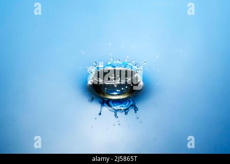 Tropfenfotografie, Wassertropfen fallen auf Wasseroberflaeche, Wassersaeule, Farbspiel, Studioaufnahme Stockfoto