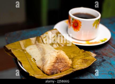 Gefülltes Tamale auf Holztisch serviert, gefülltes Tamale auf Bananenblatt auf Holztisch serviert, typisch nicaragua Essen Stockfoto