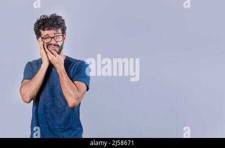 Attraktiver Junge mit Zahnschmerzen, isoliertes Bild eines Mannes mit Zahnschmerzen, Hand auf Wange mit Zahnschmerzen Stockfoto