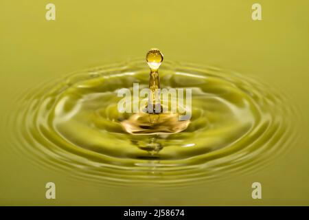 Tropfenfotografie, Wassertropfen fallen auf Wasseroberflaeche, Wassersaeule, Farbspiel, Studioaufnahme Stockfoto