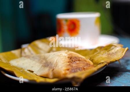 Gefülltes Tamale auf Holztisch serviert, gefülltes Tamale auf Bananenblatt auf Holztisch serviert, typisch nicaragua Essen Stockfoto