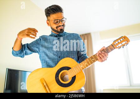 Geben Gitarre online lektion.indischer Mann spielt die Gitarre Stockfoto