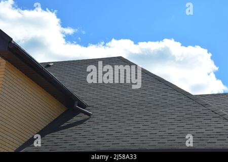 Wasserabdichtung Dachproblematik mit Asphaltschindeln und Regenrinne. Asphaltschindeln Dachkonstruktion. Stockfoto