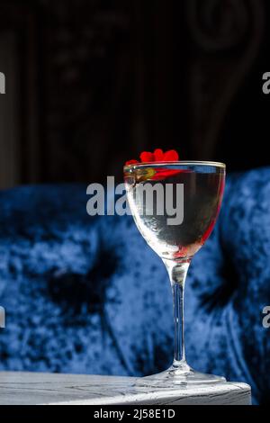 Trinken Sie ein Glas Daiquiri-Cocktail und Sommerblumen auf dem Holzschreibtisch im Freien. Erfrischender alkoholischer Zitruscocktail im Sommer Stockfoto