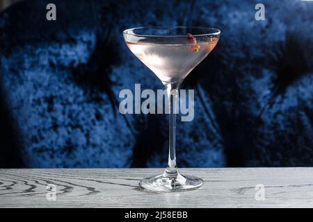 Erfrischungsgetränke im Sommer. Cocktail aus hellrosa Rosen, mit Rosenwein auf dunklem Hintergrund. Mit Rosenblüten. Speicherplatz kopieren. Stockfoto