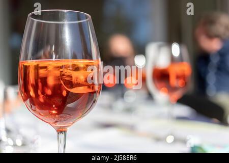 Glas mit rötlichem Aperitif auf Eis Stockfoto