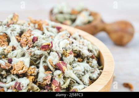 Blumentee. Getrocknet von Apfelblüten in Holzlöffel. Stockfoto