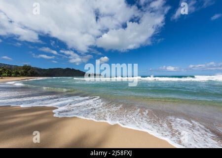 Wellen und Surfen am Hanalei Beach auf der Insel Kauai, Hawaii, USA. Fotografiert mit einem Fischaugenobjektiv, das ein verzerrtes Bild erzeugt. Stockfoto