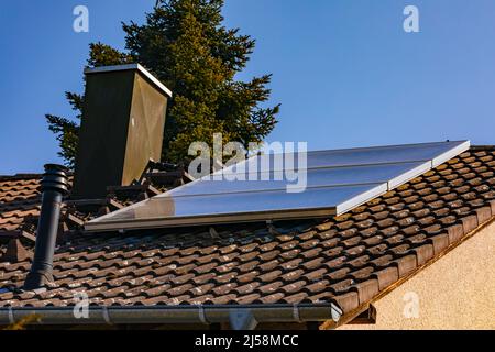 Sonnenkollektoren auf dem Dach eines Hauses verwandeln Strahlung in heißes Wasser Stockfoto