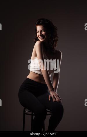 Schöne Tenage Mädchen mit Zahnspangen. Studio-Porträt vor dunklem Hintergrund. Stockfoto