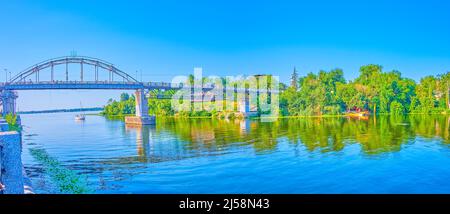 Panorama des Dnjepr-Flussdamms, der üppigen Monastyrskyi-Insel und der Fußgängerbrücke über den Fluss, Dnipro, Ukraine Stockfoto