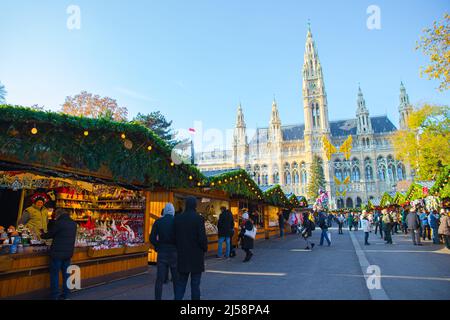 Traditioneller berühmter Weihnachtsmarkt ' Christkindlmarkt ' in Wien an einem sonnigen Wintertag mit Menschen, die herumlaufen, Österreich Stockfoto