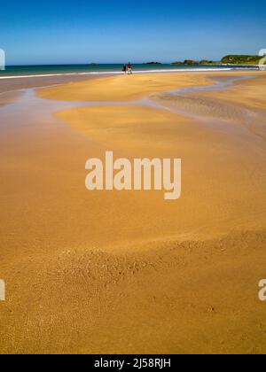 Ein paar Schritte am Ufer an einem wunderschönen Sandstrand in White Park Bay, Grafschaft Antrim Nordirland Stockfoto