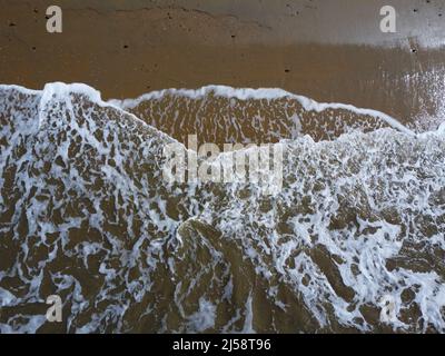 Luftaufnahme von Wellen, die am Strand waschen Stockfoto