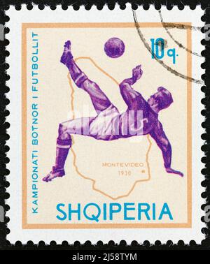 ALBANIEN - UM 1966: Eine in Albanien gedruckte Marke aus der Ausgabe 'Football World Cup - England' zeigt Fußballspieler und Karte von Uruguay (1930). Stockfoto