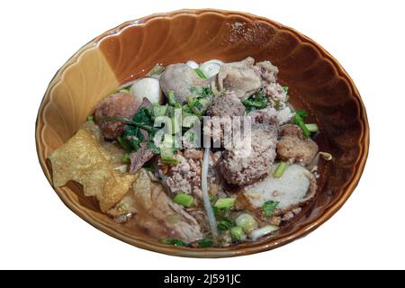 Traditionelle dünne Reisnudelsuppe (kleine Nudelsuppe) mit Fischbällchen, Garnelenfleischbällchen, gedünstetem Schweinefleisch und gebratenem Wonton in einer braunen Schüssel isoliert o Stockfoto