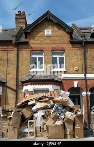 Vor einem viktorianischen Haus auf der mittleren Terrasse in twickemham, middlesex, england, stapelten sich Kartons mit ausrangierten Verpackungen und anderem Müll Stockfoto