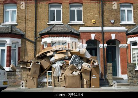 Vor einem viktorianischen Haus auf der mittleren Terrasse in twickemham, middlesex, england, stapelten sich Kartons mit ausrangierten Verpackungen und anderem Müll Stockfoto