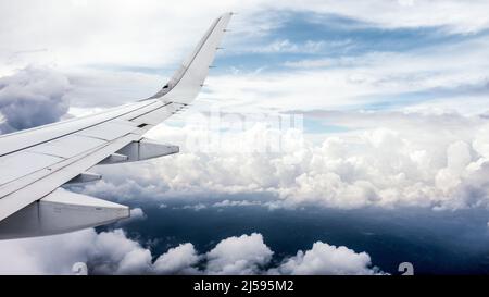 Seitenansicht aus dem Passagierflugzeug Airbus A321neo. Verträumte Wolken hinter dem rechten Flügel des Flugzeugs. Stockfoto