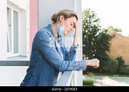 Müde Frau mit Prävention Maske gehen nach draußen mit einer frischen Luft zu atmen Stockfoto