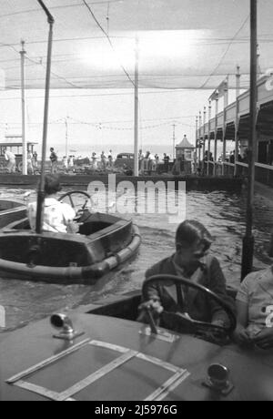 1950s, historische Urlauber, die sich in den kleinen Holzbooten am Bootspool des berühmten Beach Dreamland Pleasure Park in Margate, Kent, England, UK Vergnügen. Stockfoto