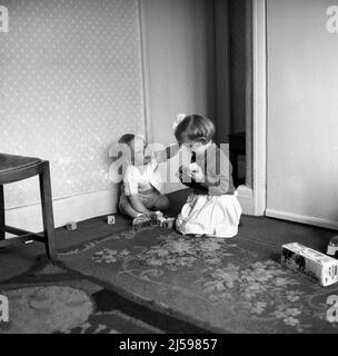 1962, historische, kleine Kinder, Bruder und Schwester spielen hölzerne Buchstabenblöcke in einem vorderen Raum, England, Großbritannien. Stockfoto