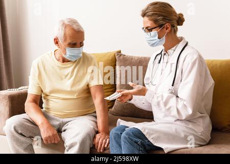 Junge Frau Arzt geben eine Konsultation zu älteren Mann während des Hausbesuchs Stockfoto