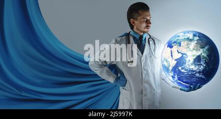 Mutiger Doktor-Superheld mit blauem Umhang, der den Planeten Erde in der Hand hält. Konzept der weltweiten Gesundheitsversorgung. Elemente dieser Bilder, die von der NASA eingerichtet wurden. Stockfoto