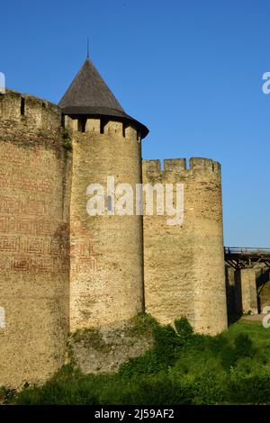 Teil der alten Steinmauer einer mittelalterlichen Festung mit Zinnen und Zinnen. Auf der rechten Seite der Brücke zum Turm Stockfoto
