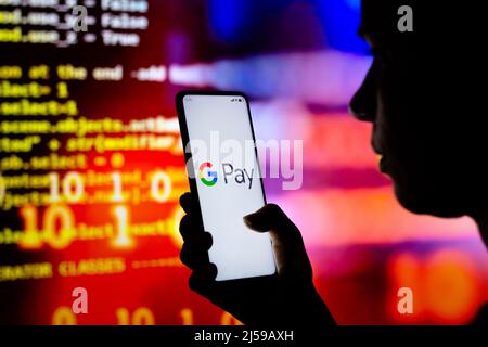 In dieser Abbildung hält eine Frau ein Smartphone mit dem Google Pay-Logo auf dem Bildschirm. Stockfoto