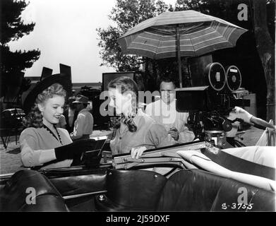 JUNE HAVER JEANNE CRAIN mit Regisseur HENRY HATHAWAY am Set offen während der Dreharbeiten zu HAUSE IN INDIANA 1944 Regisseur HENRY HATHAWAY Geschichte George Agnew Chamberlain Drehbuch Winston Miller Kameramann Edward Cronjager Musik Hugo Friedhofer Kostümdesign Bonnie Cashin Twentieth Century Fox Stockfoto