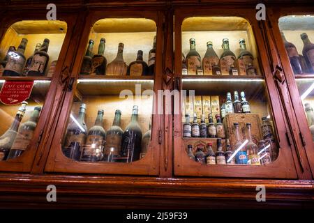 Alte alte, mit Staub bedeckte Flaschen hinter dem Glas in der andalusischen Jugendstilbar Europa, Alfalfa, Sevilla, Spanien Stockfoto