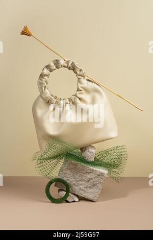 Konzeptionell kreativ modernes Stillleben, Balance Komposition.Beige Handtasche aus Kunstleder auf minimalistischem Hintergrund. Stockfoto