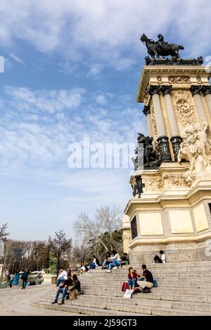 Jugendliche Touristen sitzen in der Nähe von Teich im El Retiro Park, Madrid, Spanien Stockfoto