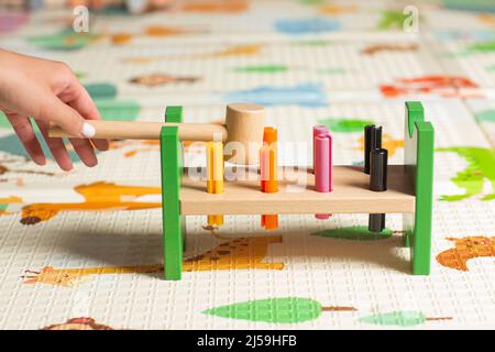 Holzspielzeug für Kinder. Das Kind sammelt einen Sortierer. Pädagogische Logik Spielzeug für Kinder. Kinderhände aus nächster Nähe. Montessori Spiele für Kinder Entwickler Stockfoto