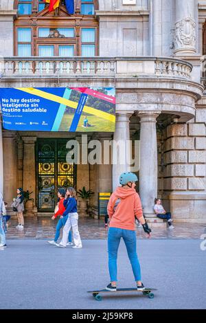 Ein junger Mensch Skateboards vor dem Casa Consistorial oder Rathaus. Das Gebäude befindet sich in der Plaza del Ayuntamiento oder Rathaus Stadt aufhört Stockfoto