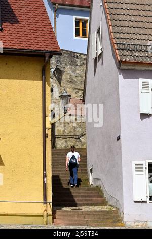 Breisach, Deutschland - April 2022: Person geht Schritte zwischen Gebäuden bis zum Stephansdom Stockfoto