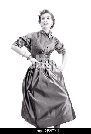 1950S FRAU MODELL TRAGEN HEMD TAILLE KLEID MIT PUSH-UP-ÄRMELN GÜRTEL GEFLISSENE MITTELRIFF UND VOLLER ROCK AUFGESCHLAGEN KRAGEN - F838 CRR001 HARS B&W BROSCHE STILE UND BERUFE POSIEREN PLISSIERTEN STILLLEBEN ÄRMEL STILVOLLE AUFRICHTIGE MODELLIERUNG PUSH-UP FEIERLICHE ARMBÄNDER MODE FOKUSSIERTE INTENSIVE MIDRIFF MODELLIERUNG POSE TAILLE JUNGE ERWACHSENE FRAU SCHWARZ UND WEISS SORGFÄLTIGE KAUKASISCHE ETHNIE ERNSTHAFT ABSICHT ALTMODISCH Stockfoto